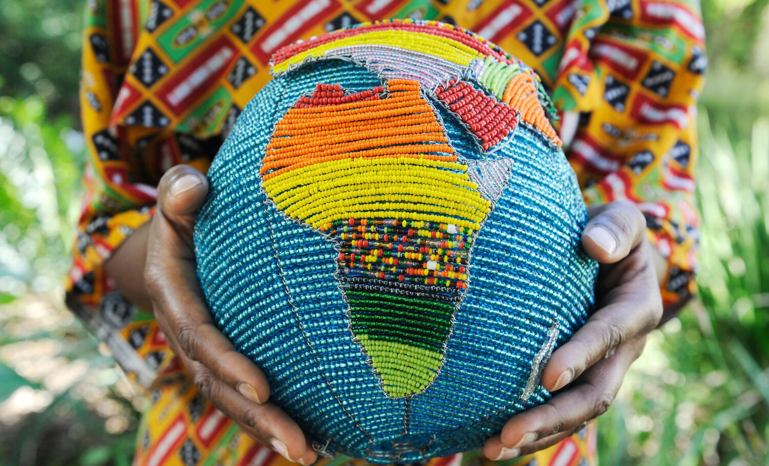 Woman holding a beaded globe with Africa showing